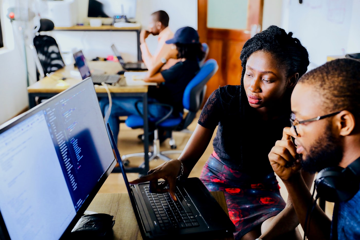 A small cohort of professionals working on laptops during an AI income skills course